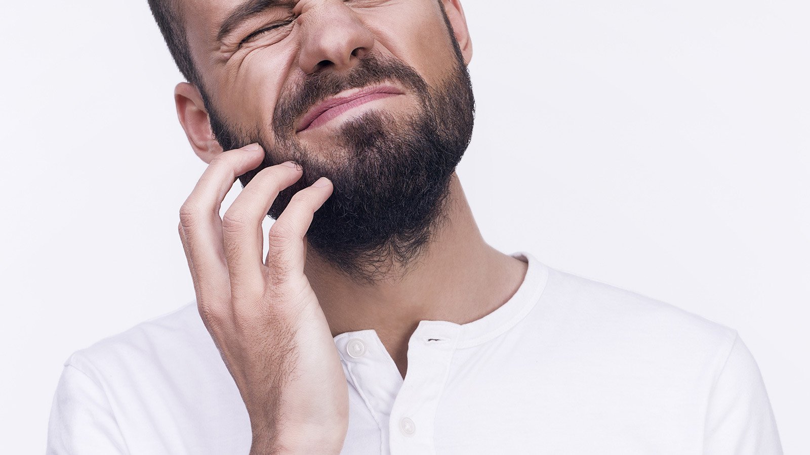 A closeup shot of a man itching his beard