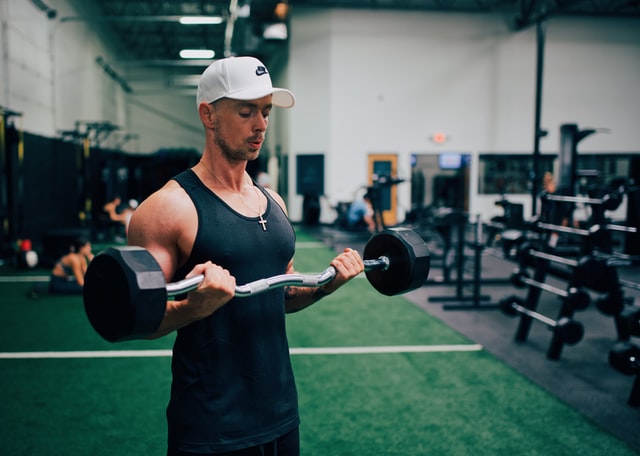 A man pulls up a weight bar in a gym
