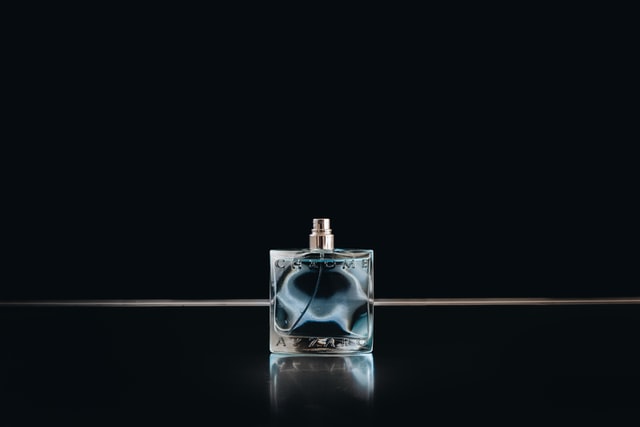 A portrait of a scent bottle in dark background as advertising concept