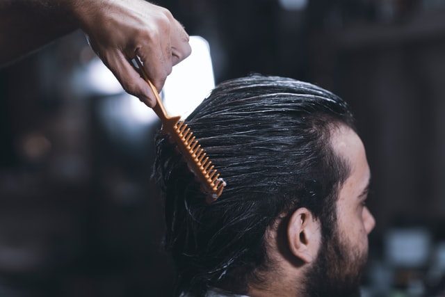 A closeup portrait of a man's hair combing at barber shop