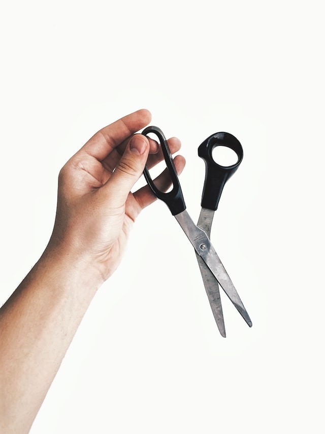 A hand holding a normal hair scissors