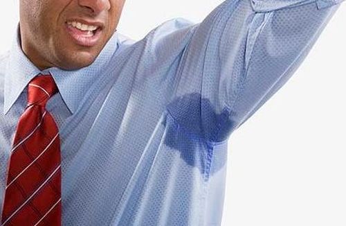 A closeup portrait of a man's underarm sweating