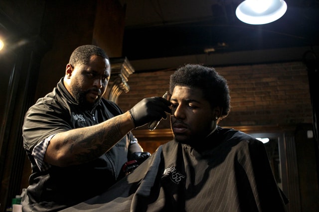 A man cutting his hair on barber shop