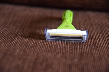 A portrait of a light green color razor on a table