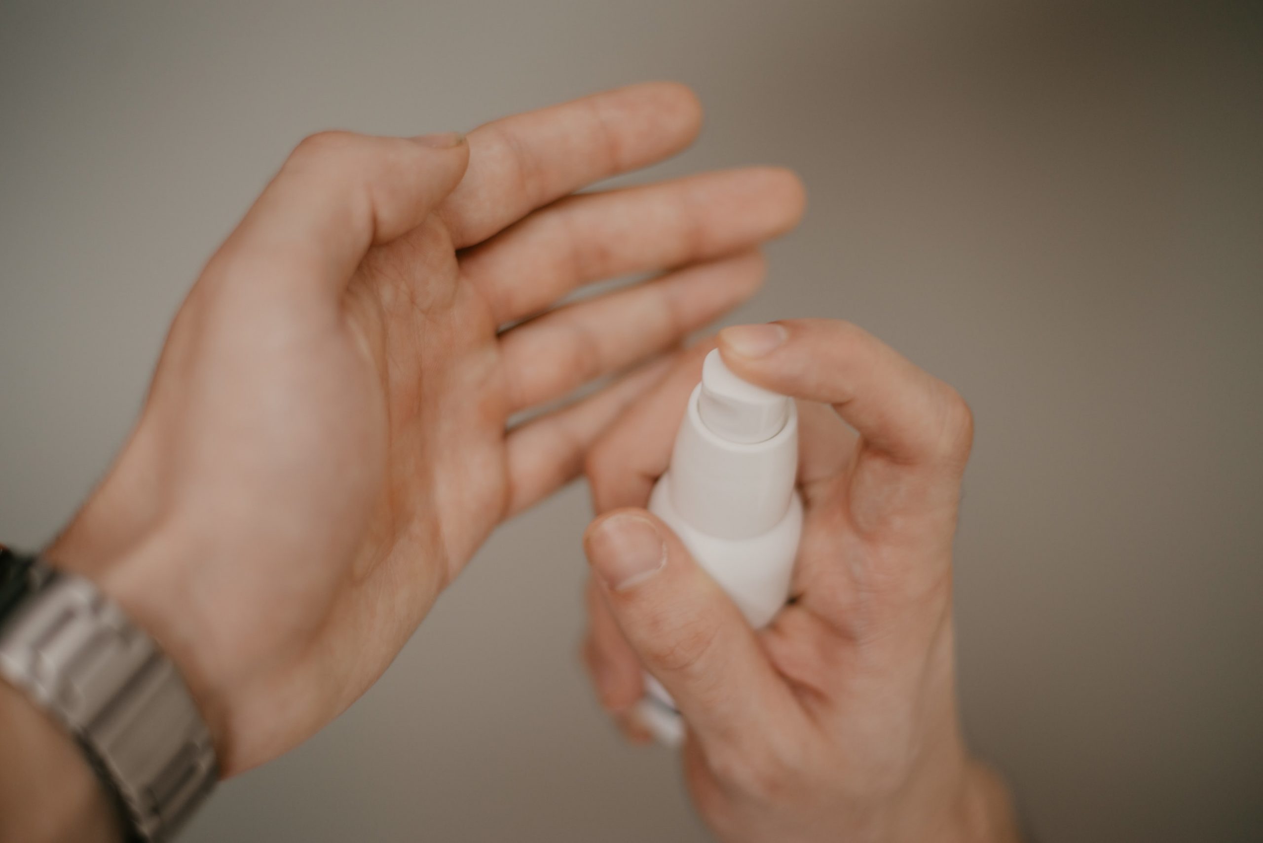 A man pouring lotion on his hand