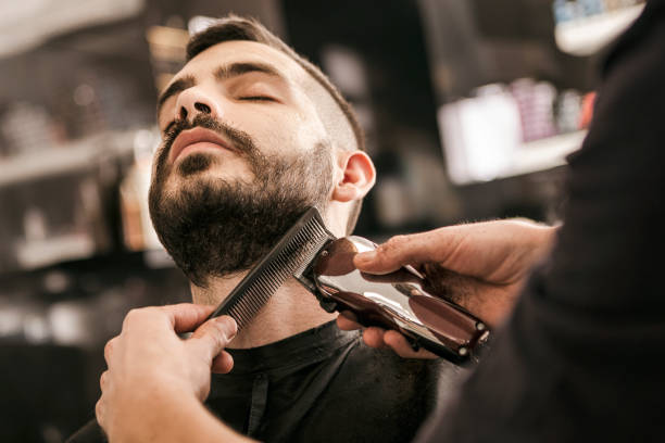 Man getting his beard trimmed at barbershop 