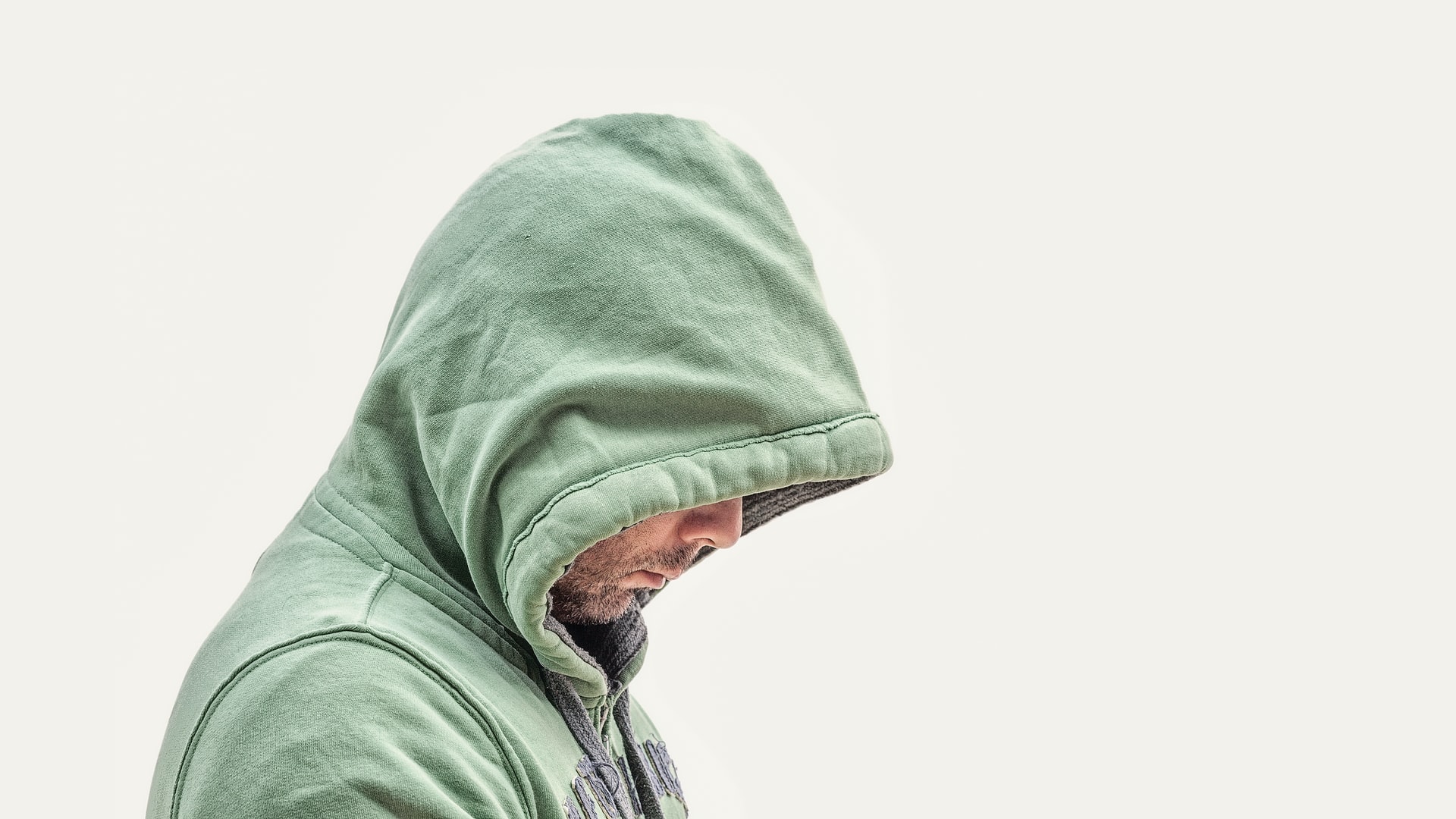 Portrait of a man's half showing face while wearing a hoodie